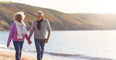 Couple de retraités heureux marchant sur la plage