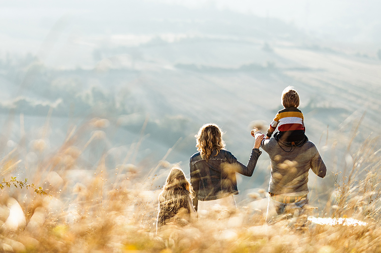 Image d’une famille de dos regardant l’horizon.