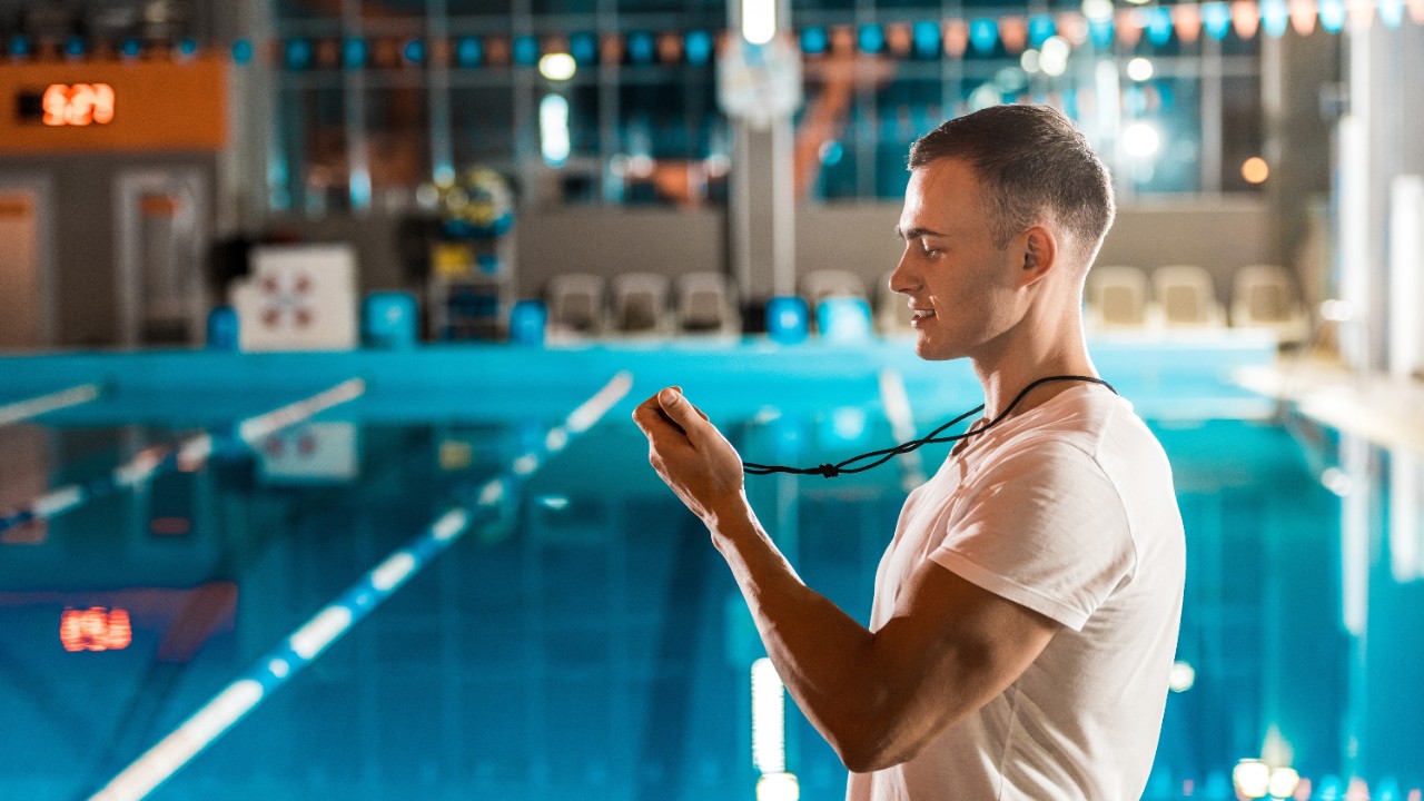 une personne qui chronomètre à la piscine.