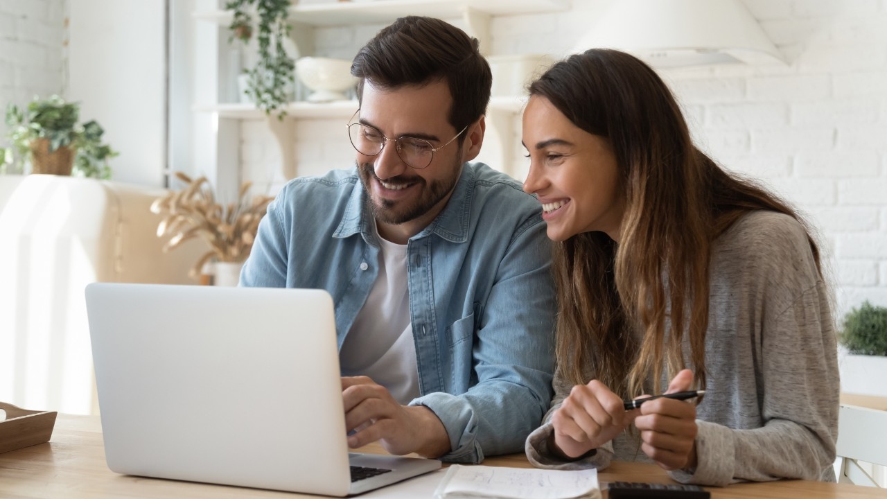 Un homme et une femme qui consultent un ordinateur portable.