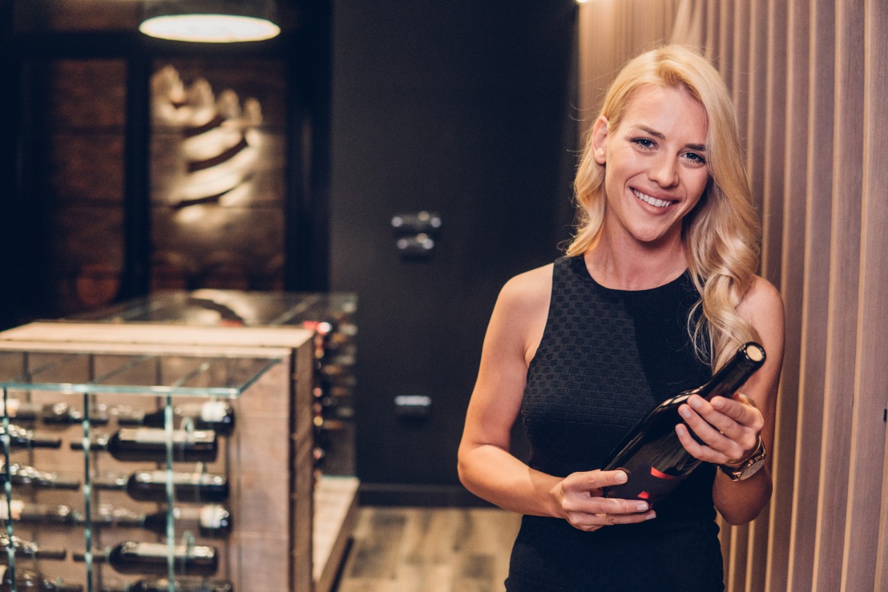 Une femme qui tient une bouteille de vin.