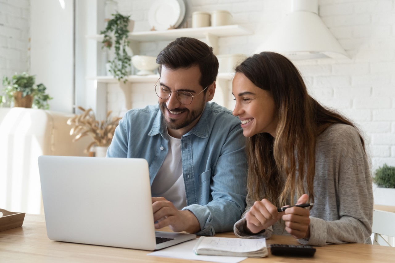 Un homme et une femme qui consultent un ordinateur portable.