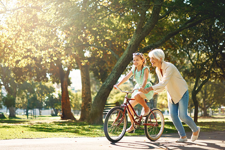 Une femme qui apprend à une jeune fille à faire du vélo.
