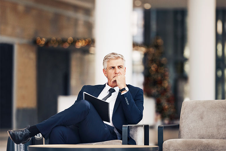 Un homme qui réfléchit assis sur une chaise.