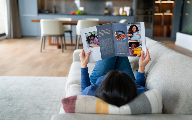 femme sur un divan lisant un article