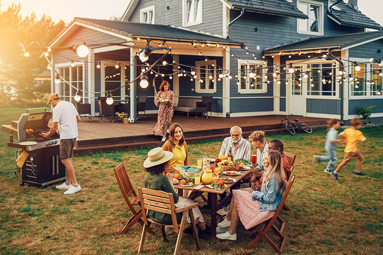 Grande famille diversifiée et amis célébrant à l'extérieur à la maison.