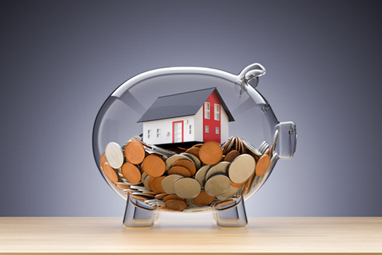 Maison modèle sur l'argent à l'intérieur de la tirelire transparente