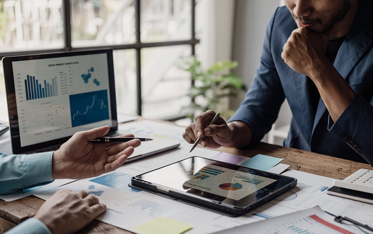 Deux hommes analysant des graphiques et des répartitions.