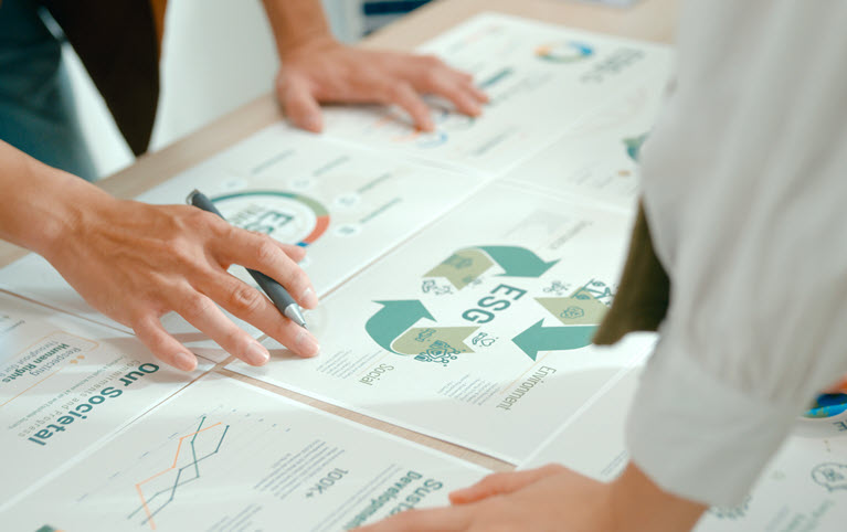Deux personnes penchées sur une table sur laquelle se trouve des rapports