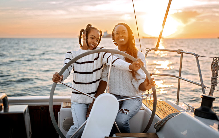 Une mère et sa fille pilotant un catamaran.