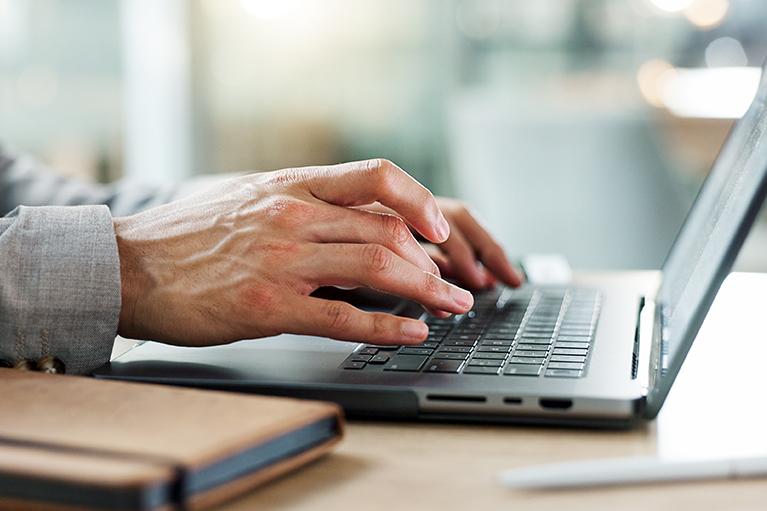 Un client regardant des articles récents et nouvelles sur un ordinateur, de son conseiller en gestion de patrimoine offrant des conseils financiers personnalisés et des stratégies d'investissement. 
