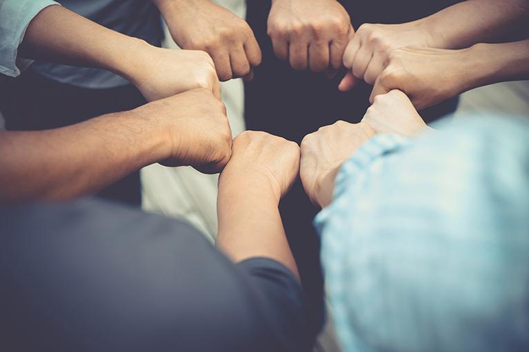 Photo des mains des membres d’une équipe symbolisant l’effort collectif. 