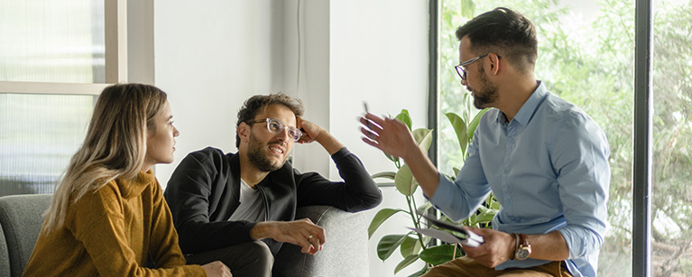 Photo d'un couple discutant avec leur conseiller en gestion de patrimoine. 