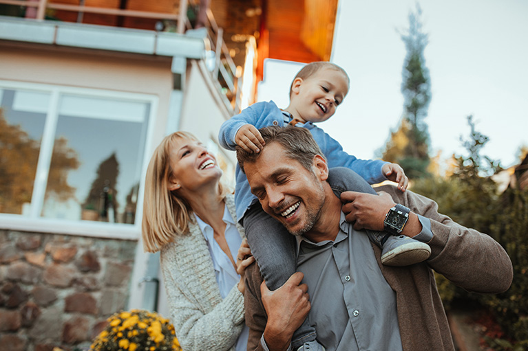 Famille heureuse à l'extérieur de la maison.