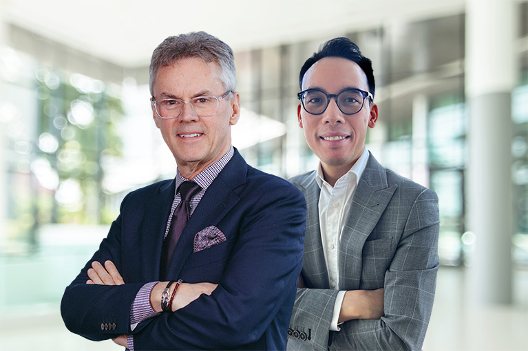 Un homme et une femme regardent un cahier dans un bureau vitré.