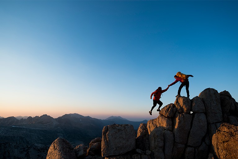 Deux personnes escaladant une montagne.