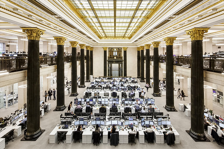 Un grand espace avec des gens travaillant devant leurs écrans d'ordinateurs.