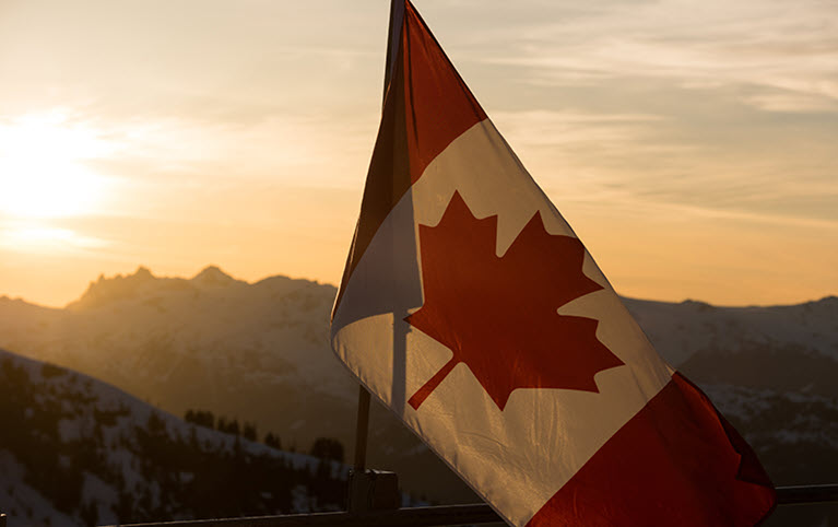 Le drapeau canadien flotte au coucher du soleil et représente le budget fédéral.