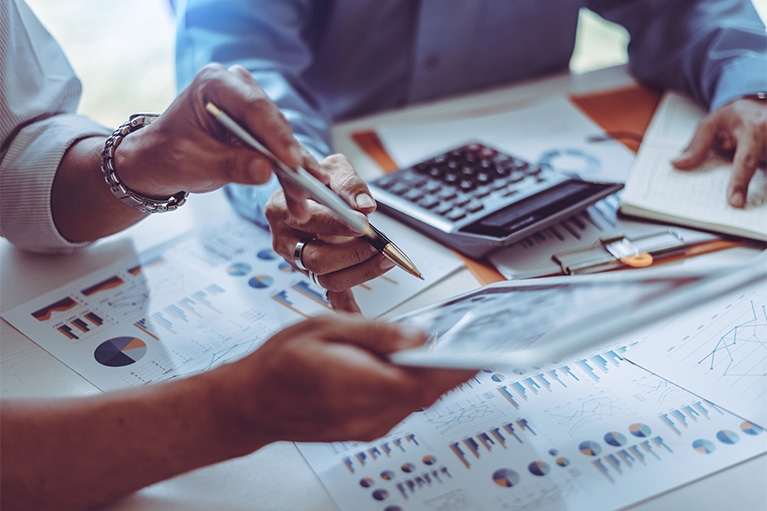 Un homme et une femme travaillent sur des documents financiers. 