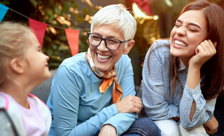 Photo de trois femmes de générations différentes qui se regardent en souriant