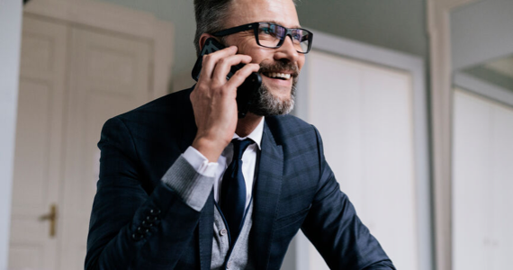 Homme en costume, souriant, au téléphone avec son conseiller